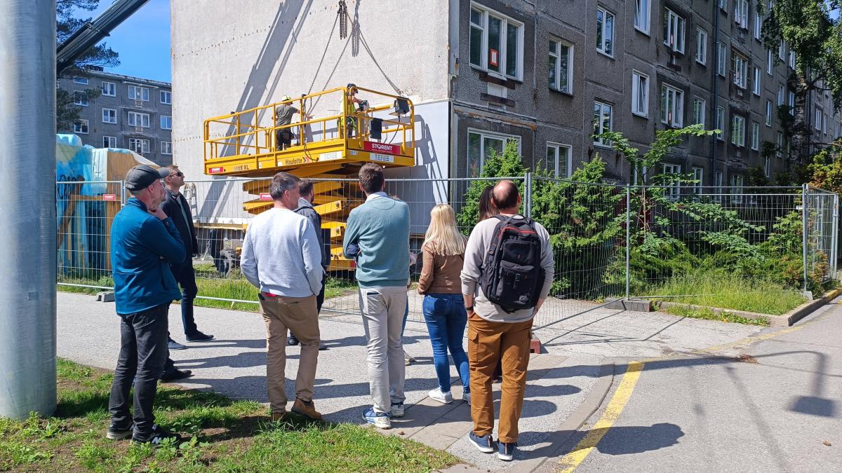 Attendees witness a building receiving renovation works.